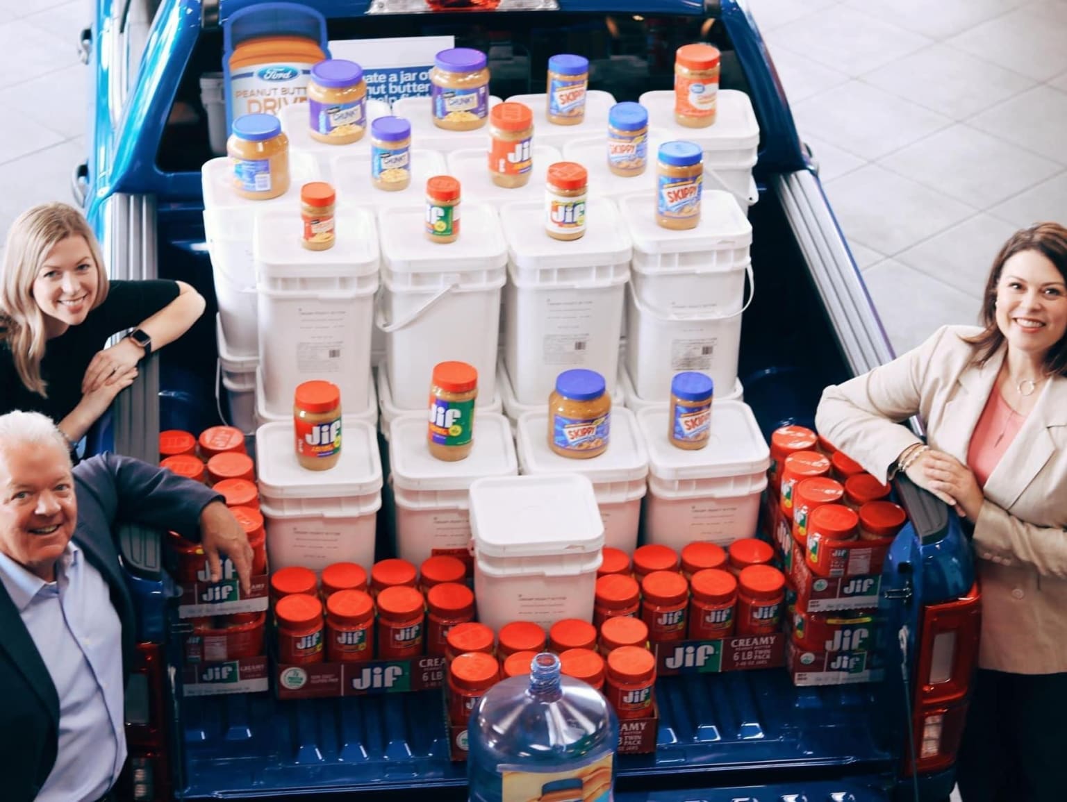 The image shows a shopping cart filled with various household cleaning products, including bottles of detergent, bleach, and other cleaning supplies.