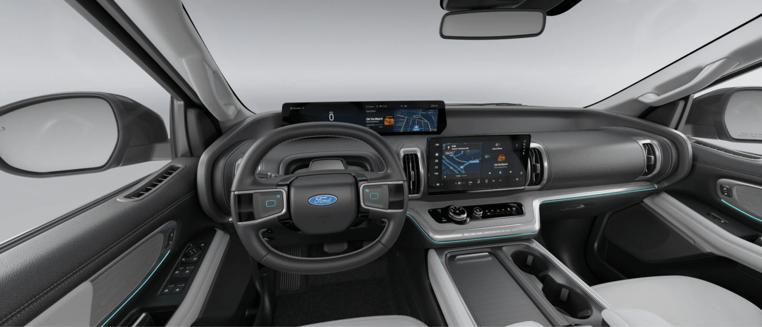 Car interior with steering wheel and digital displays on bright background.