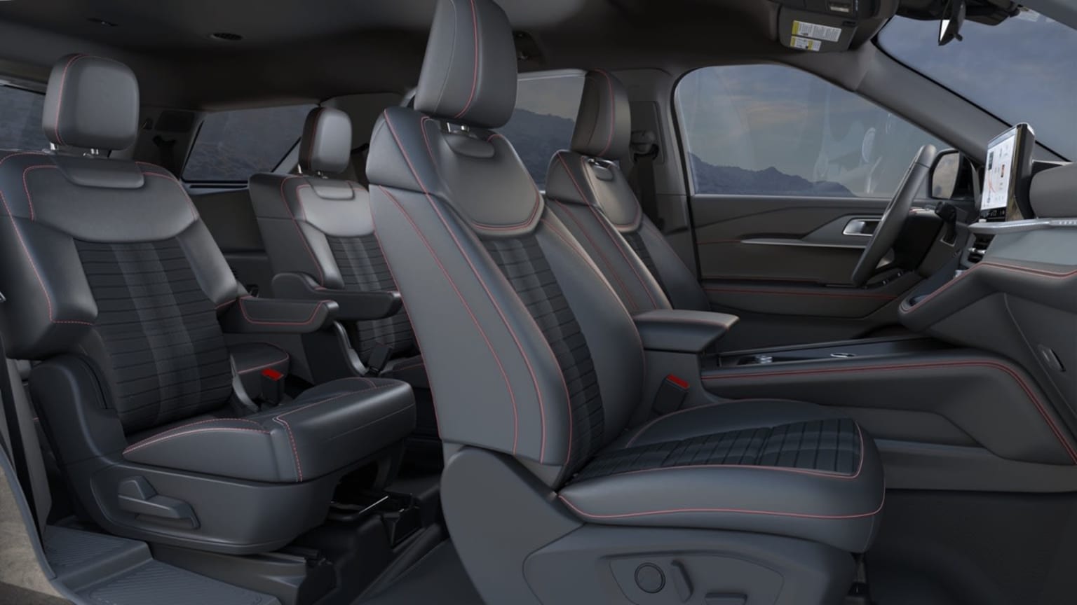 Interior of a vehicle with multiple rows of comfortable-looking seats and a spacious layout. The background appears dark, suggesting the vehicle is enclosed or in a dimly lit environment.