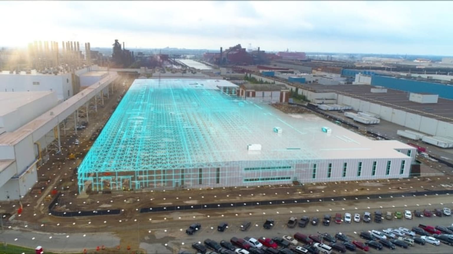 an aerial view of a large building with a large pool in the middle of the building and lots of cars parked in front of it