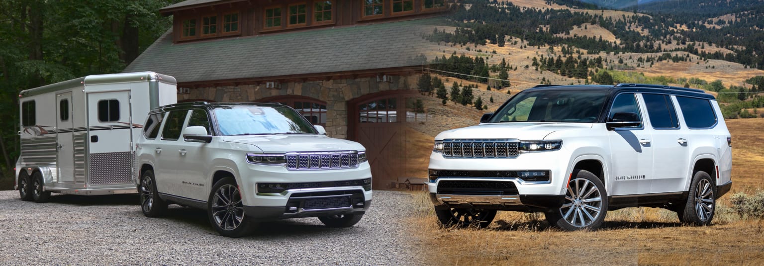 a white truck and a white suv parked in front of a mountain house with a horse trailer in front of it