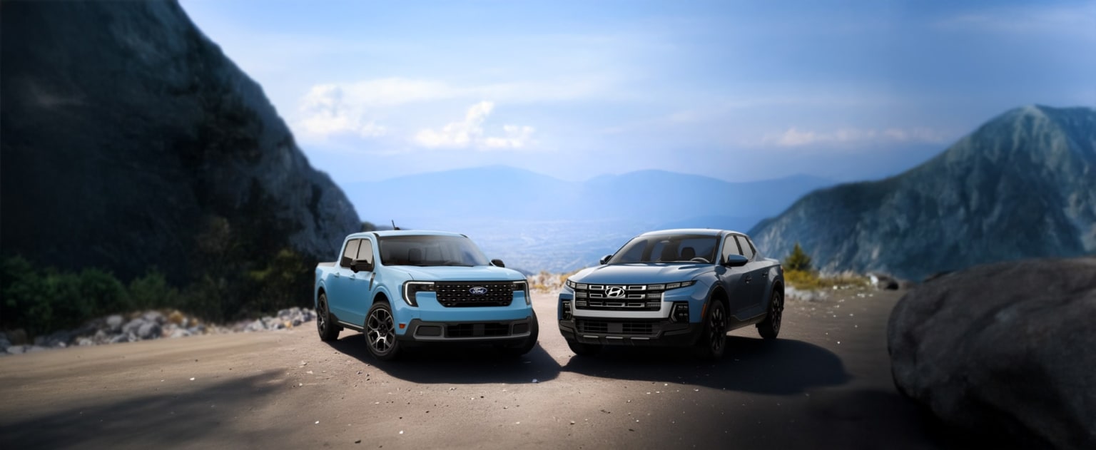 Off-road vehicles parked on a dirt road with a mountainous landscape and cloudy sky in the background.