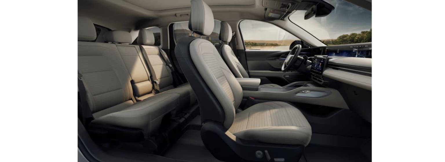 Interior of a vehicle with comfortable leather seats, modern dashboard, and scenic landscape visible through the windshield.