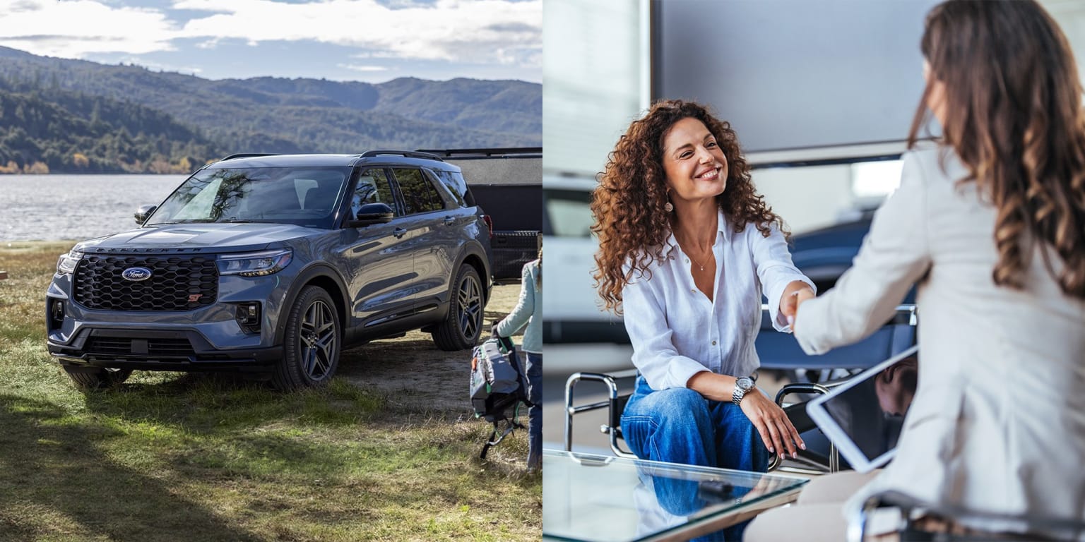 An SUV parked in a grassy area with mountains and a lake in the background, and two women standing and conversing in the foreground.