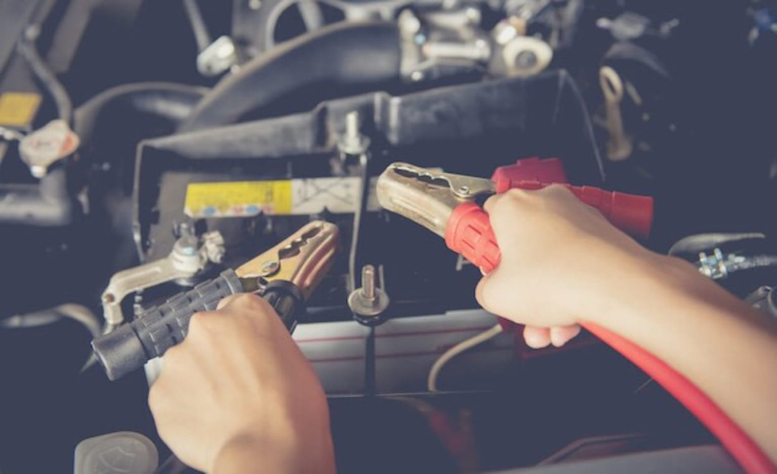 a person working on a car's engine with a wrench and a wrench in their hand