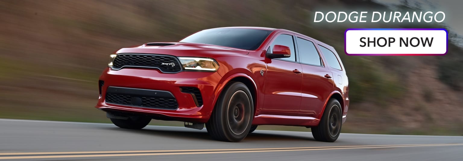 a red suv driving down a road next to a sign that says dodge dupresse shop now
