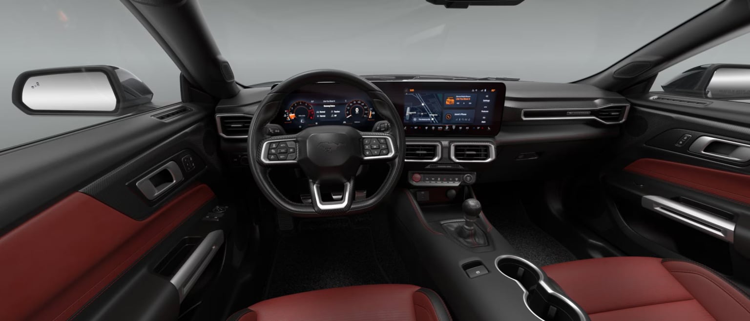 Interior of a modern vehicle with a sleek dashboard, steering wheel, large touchscreen display in the center console. Seats upholstered in vibrant red, creating a striking contrast with dark gray and black tones of the cabin.