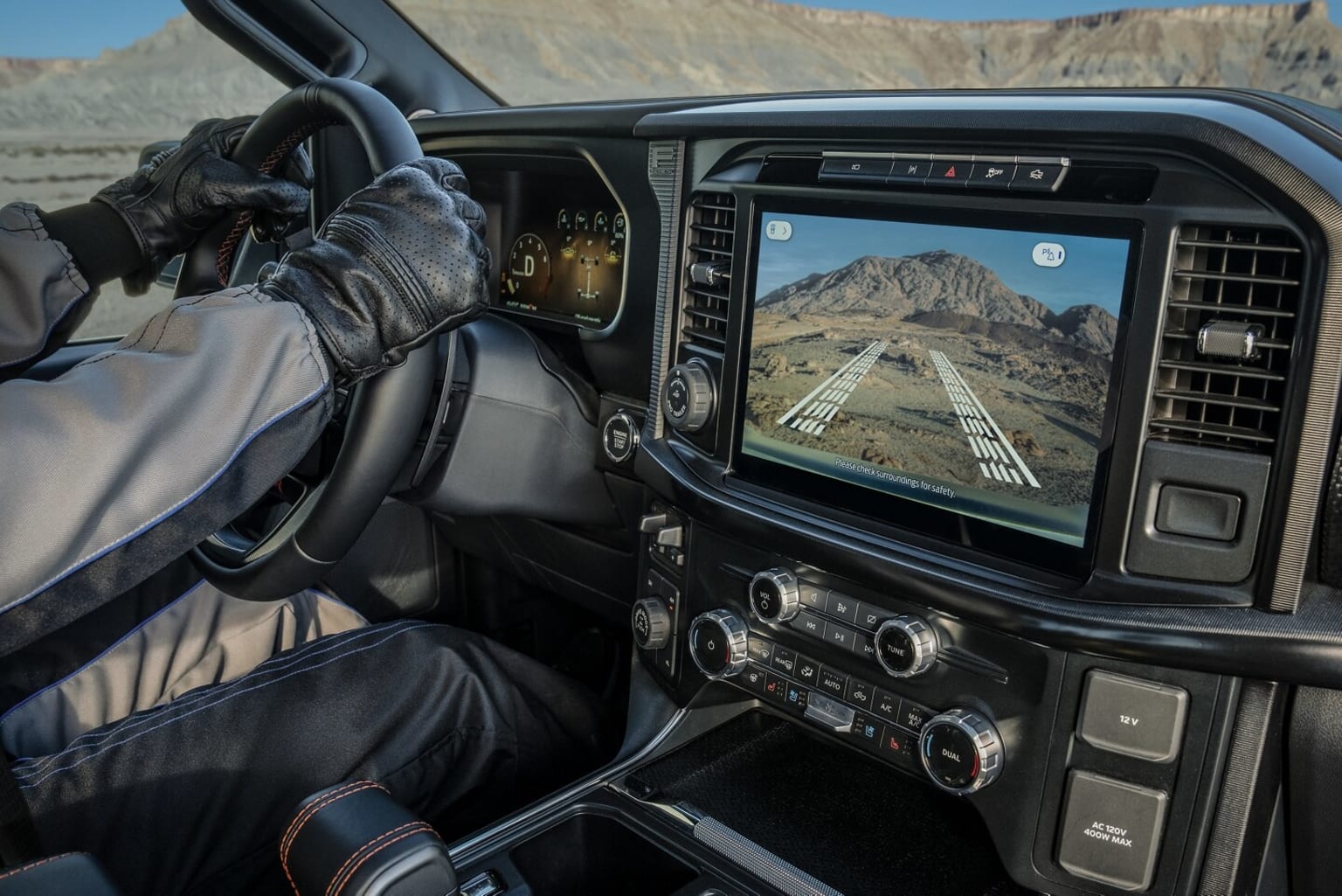Interior of a vehicle with a large display screen showing a mountainous landscape.