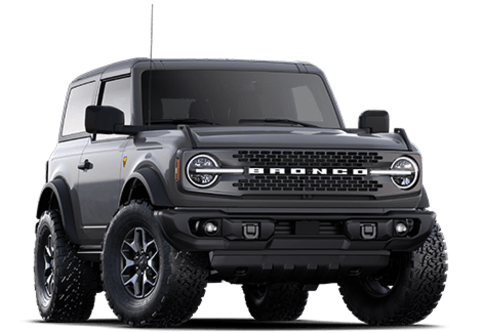 An off-road-ready SUV in a matte gray color with a prominent grille and large tires, stands prominently in the frame.