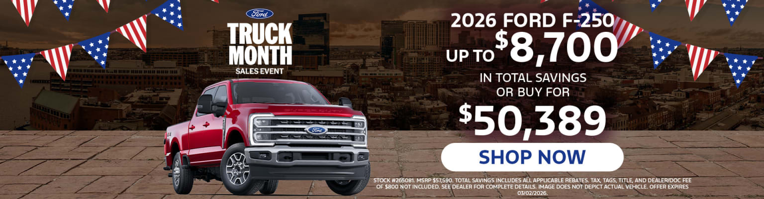 The image features a red truck prominently displayed in the foreground, with a promotional advertisement for a "Truck Month Sales Event" and details about the 2026 model and its pricing options in the background.