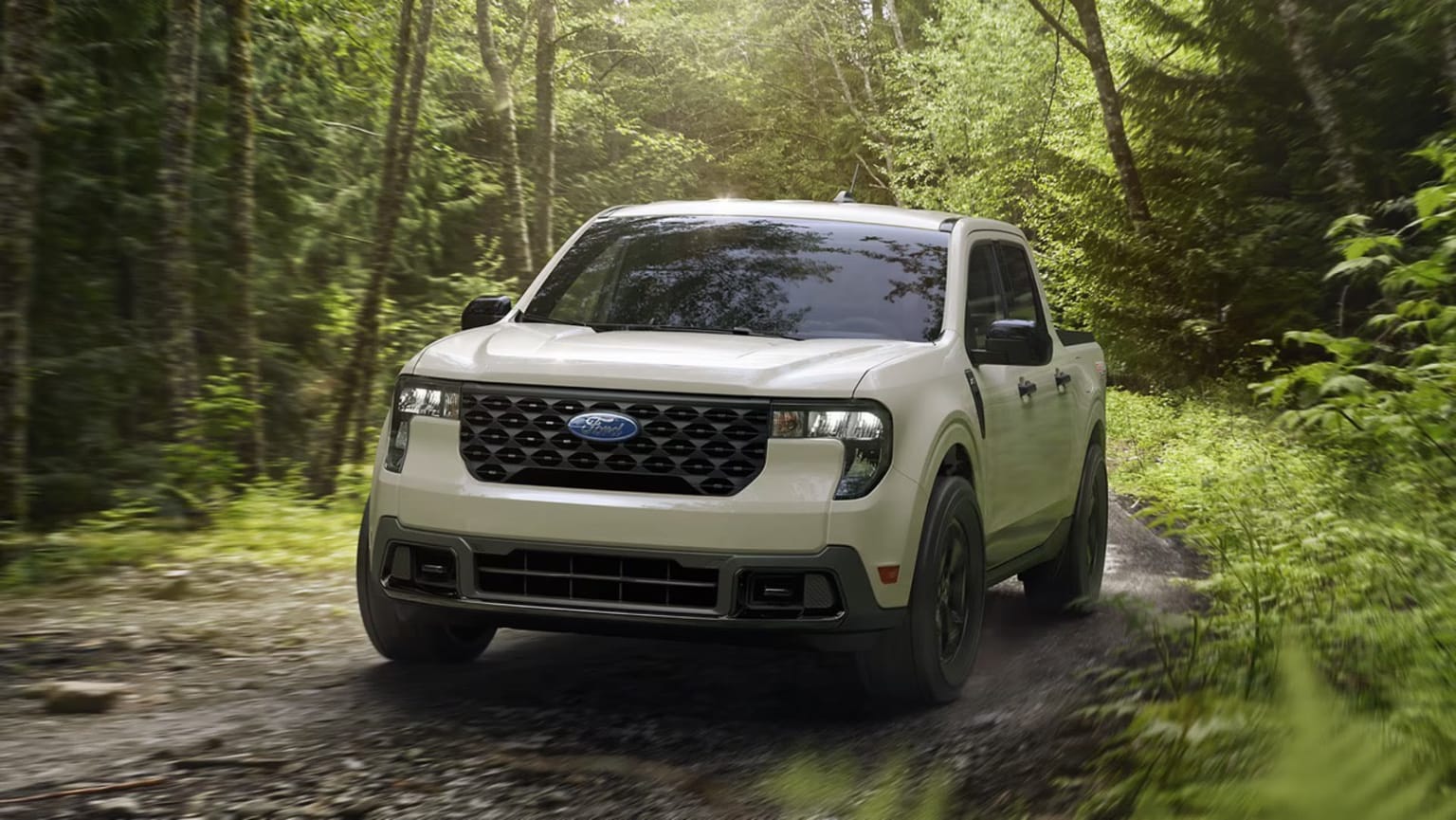 A white off-road vehicle navigates a dirt path through a lush, verdant forest environment.
