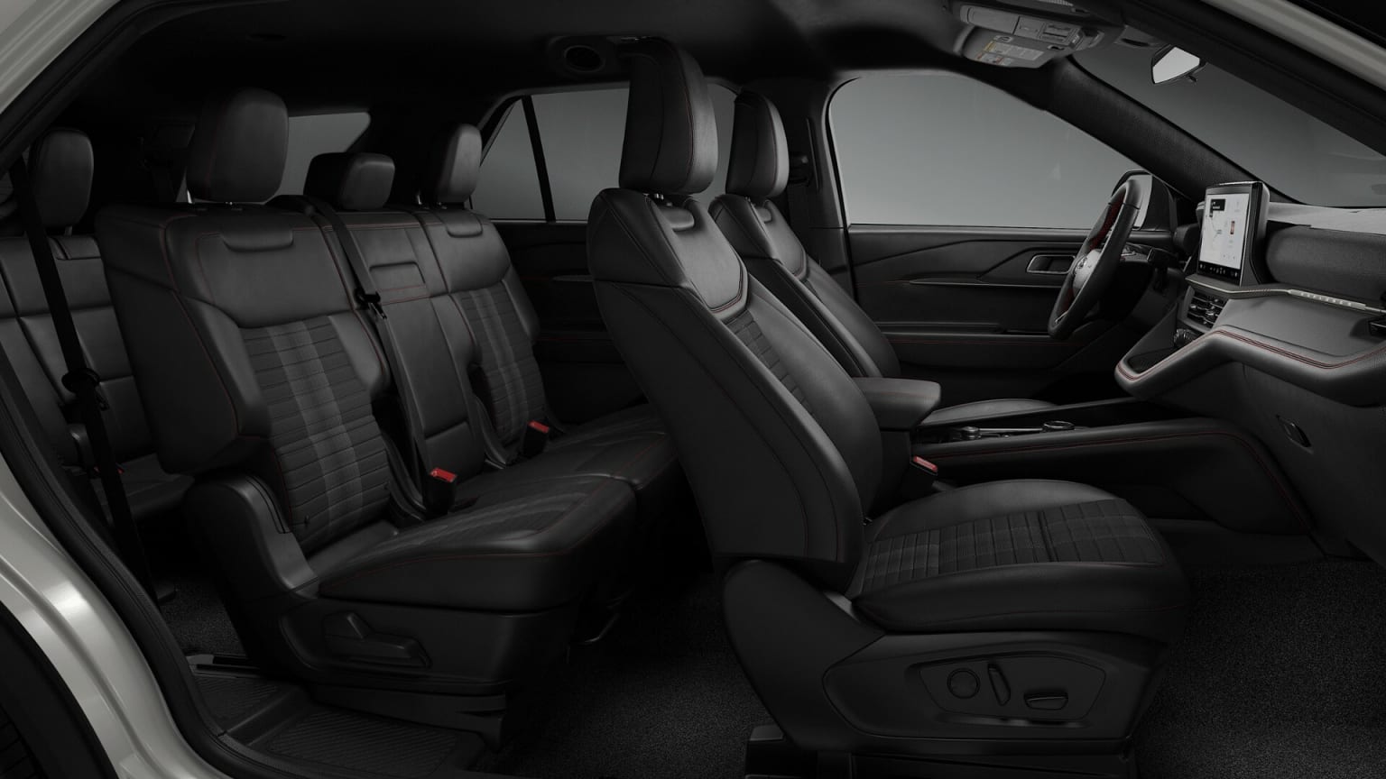 The image shows the interior of a vehicle, with multiple rows of black leather seats and various controls and features visible in the background.