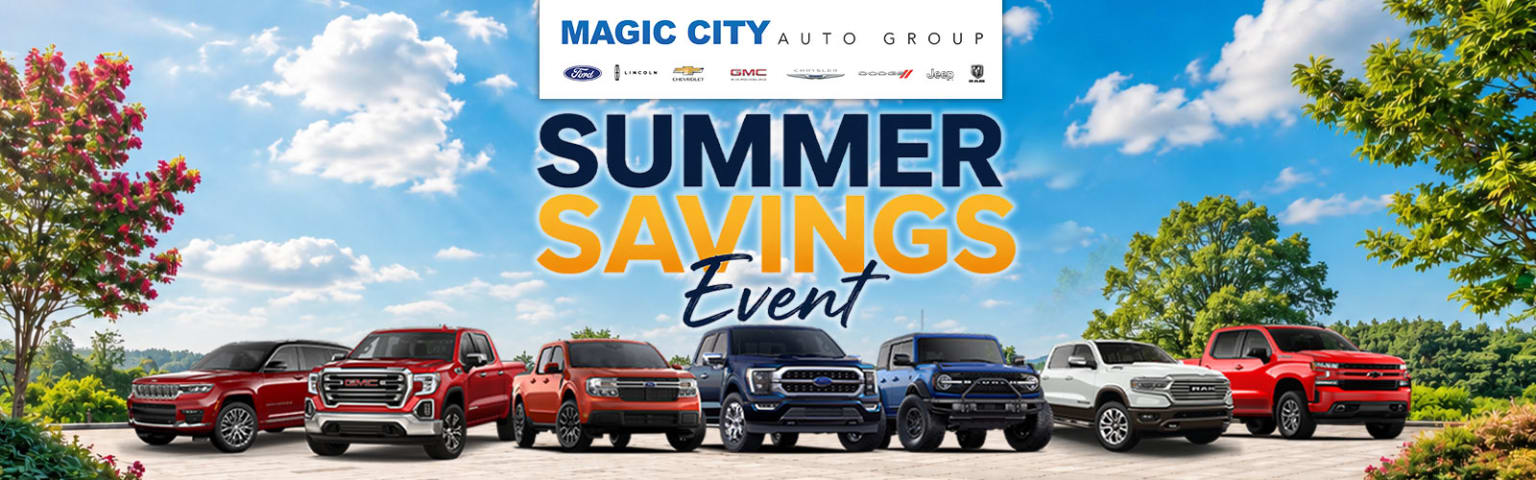 New trucks and SUVs on display with bright blue sky and fluffy clouds in the background.