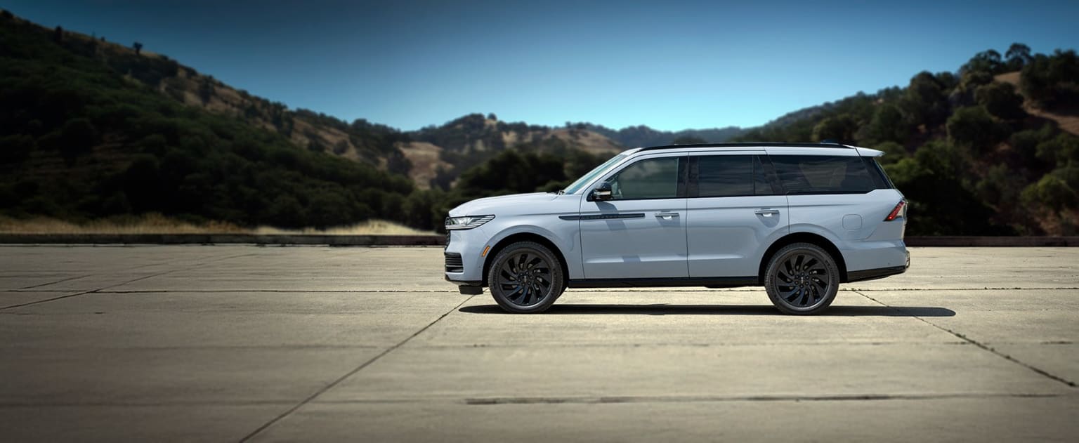 SUV parked on a concrete surface with mountainous landscape in the background.