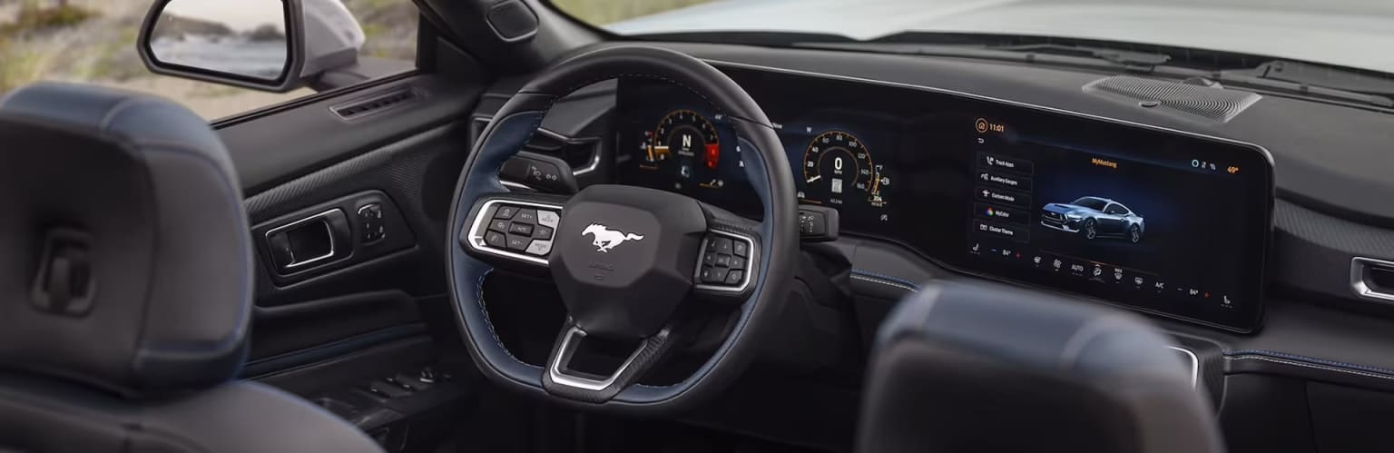 The image depicts the interior of a contemporary vehicle, featuring a steering wheel, dashboard, and a variety of controls and displays. The background showcases the vehicle's interior with a stylish and minimalist design.