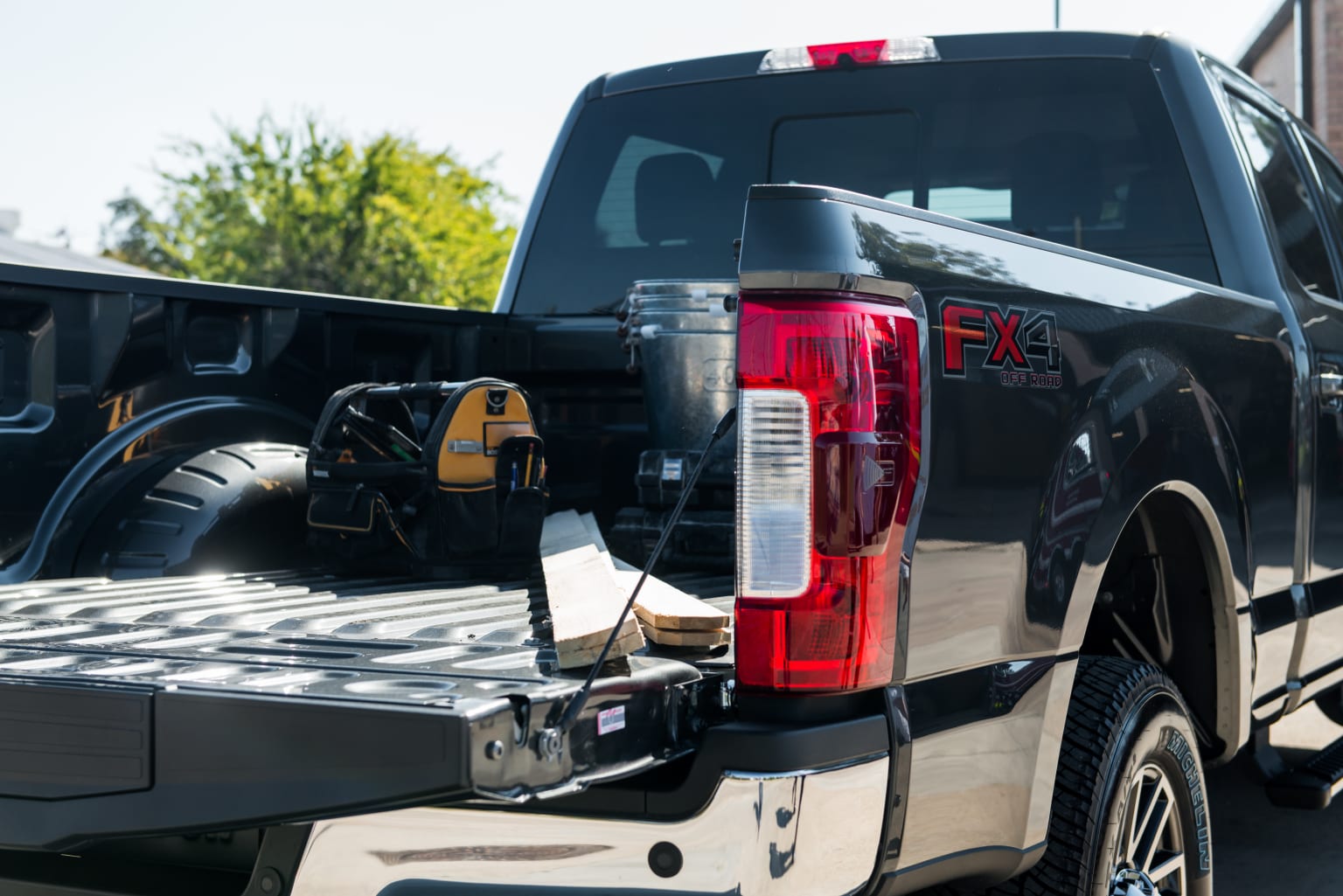 a black truck with a flatbed and a flatbed trailer attached to it's flatbed is parked in a parking lot