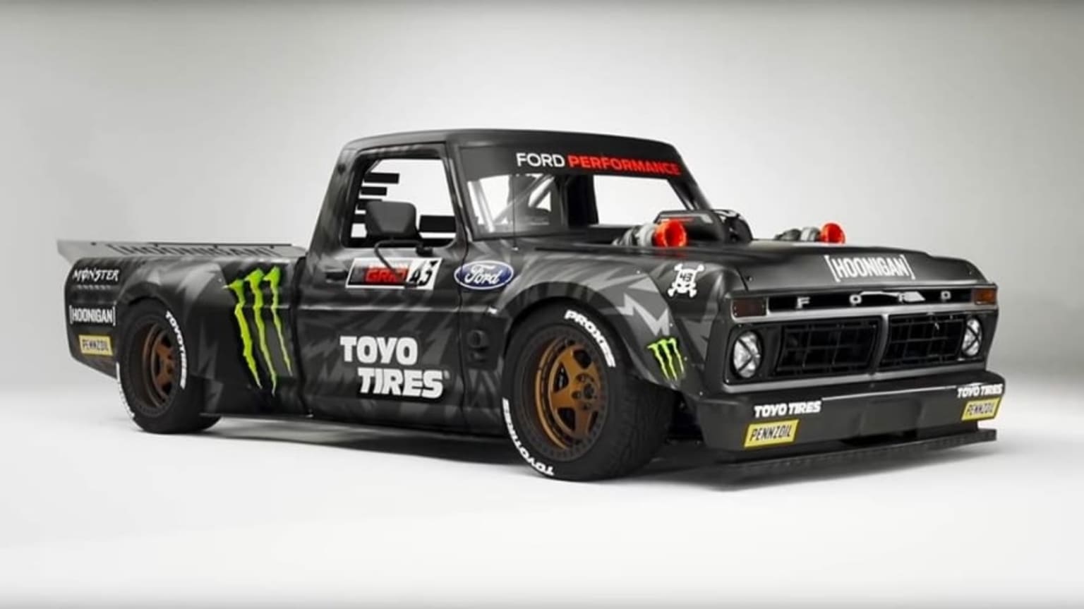 a monster truck with a monster logo on the back of it's truck bed and a monster logo on the front of the truck