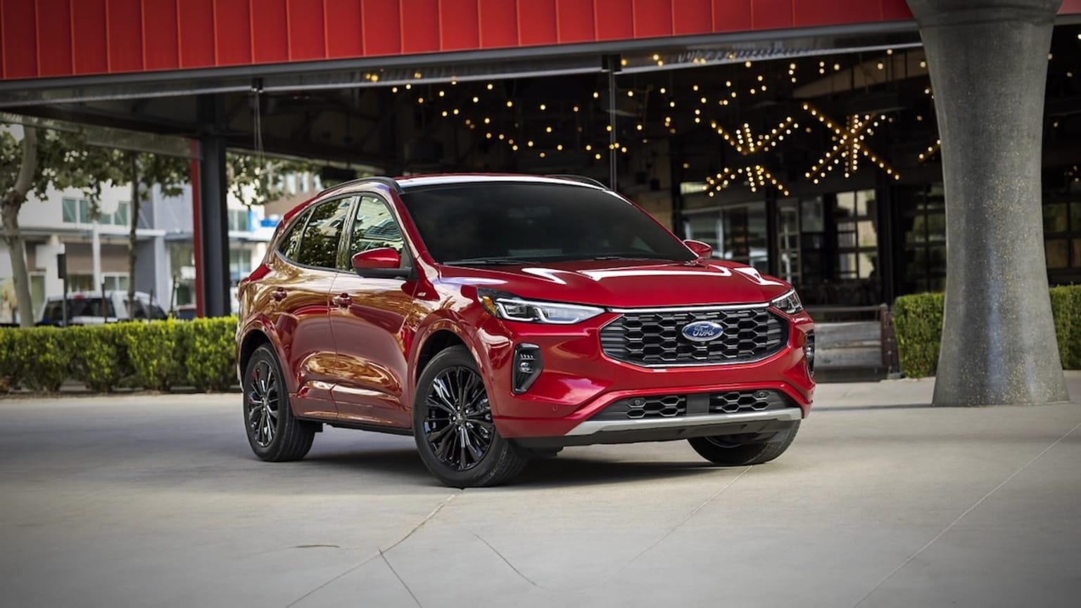 2025 Ford Escape red metallic exterior color, parked outside a building with a string of lights behind it