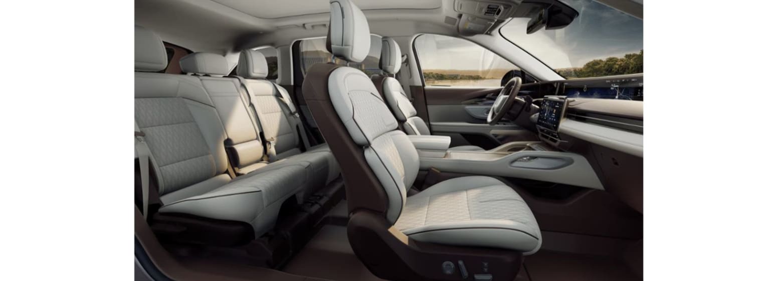 The image shows the interior of a vehicle with leather seats and a dashboard visible, and a scenic landscape through the windshield in the background.
