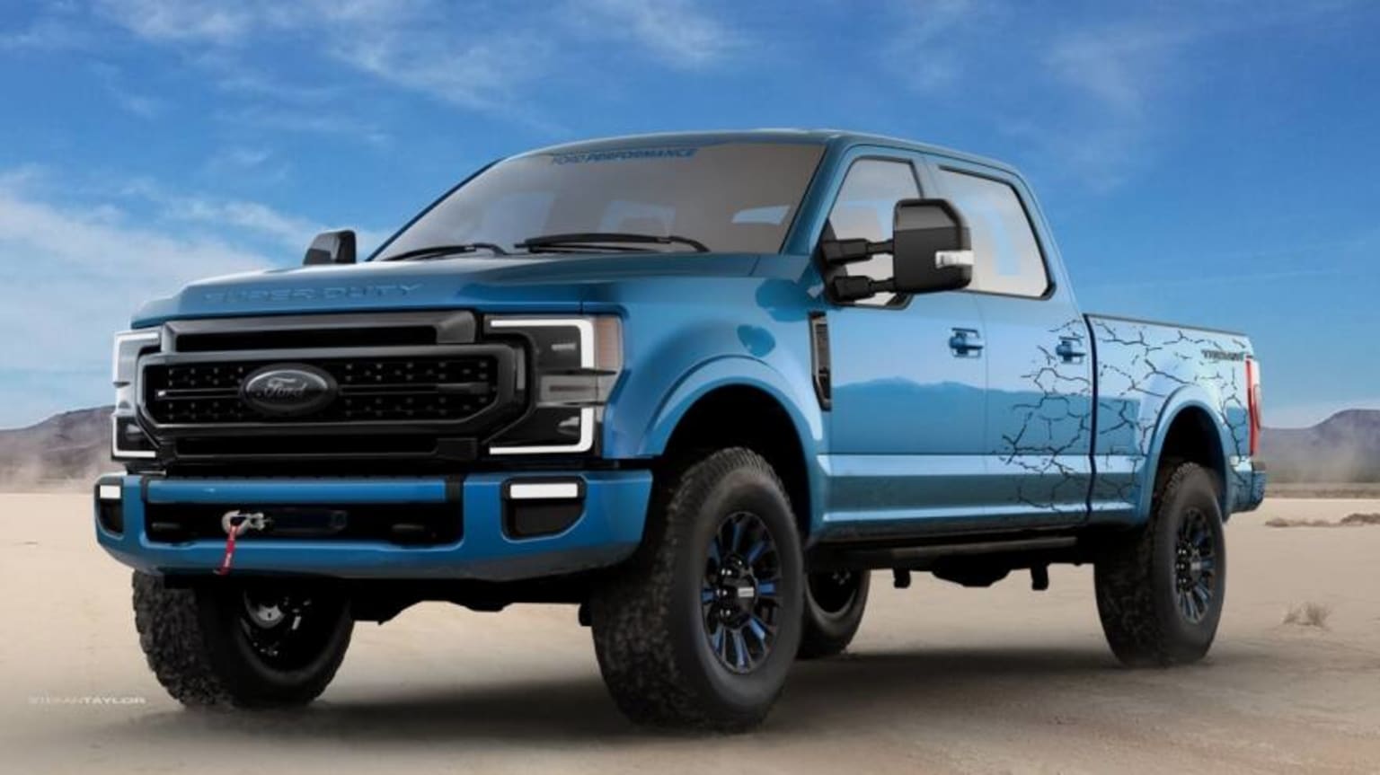 a blue truck is parked in the middle of a sandy area with mountains in the background and a blue sky