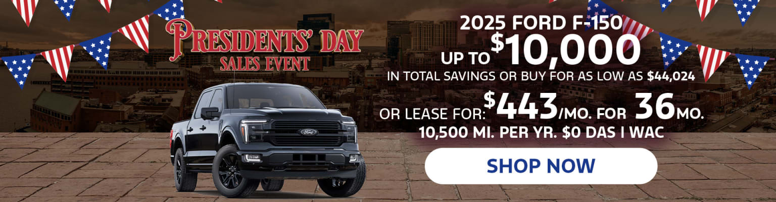 The image shows a large black pickup truck in the foreground, with a Presidents' Day sales event advertisement in the background featuring details about the vehicle's financing options.