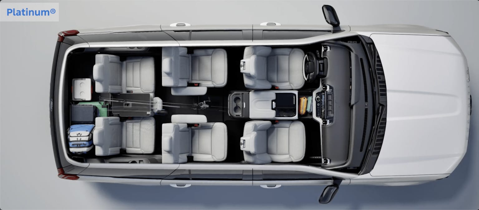 A silver van with its rear doors open, revealing a spacious interior filled with various storage compartments and equipment.