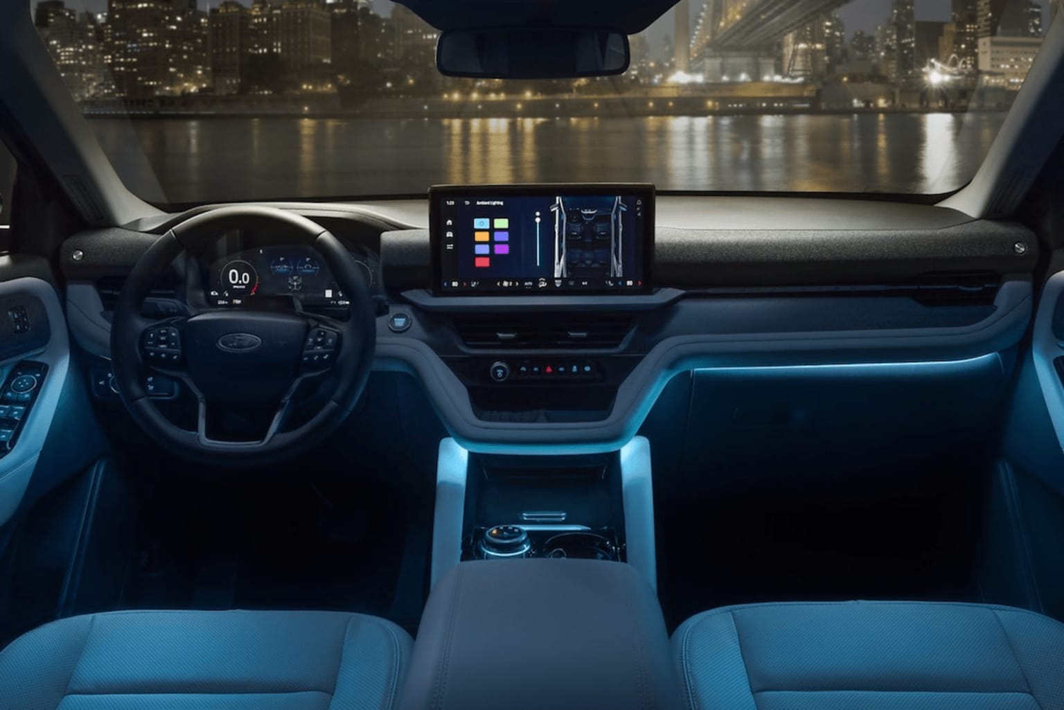 Interior of a modern vehicle with a large display screen and ambient lighting, overlooking a cityscape at night.