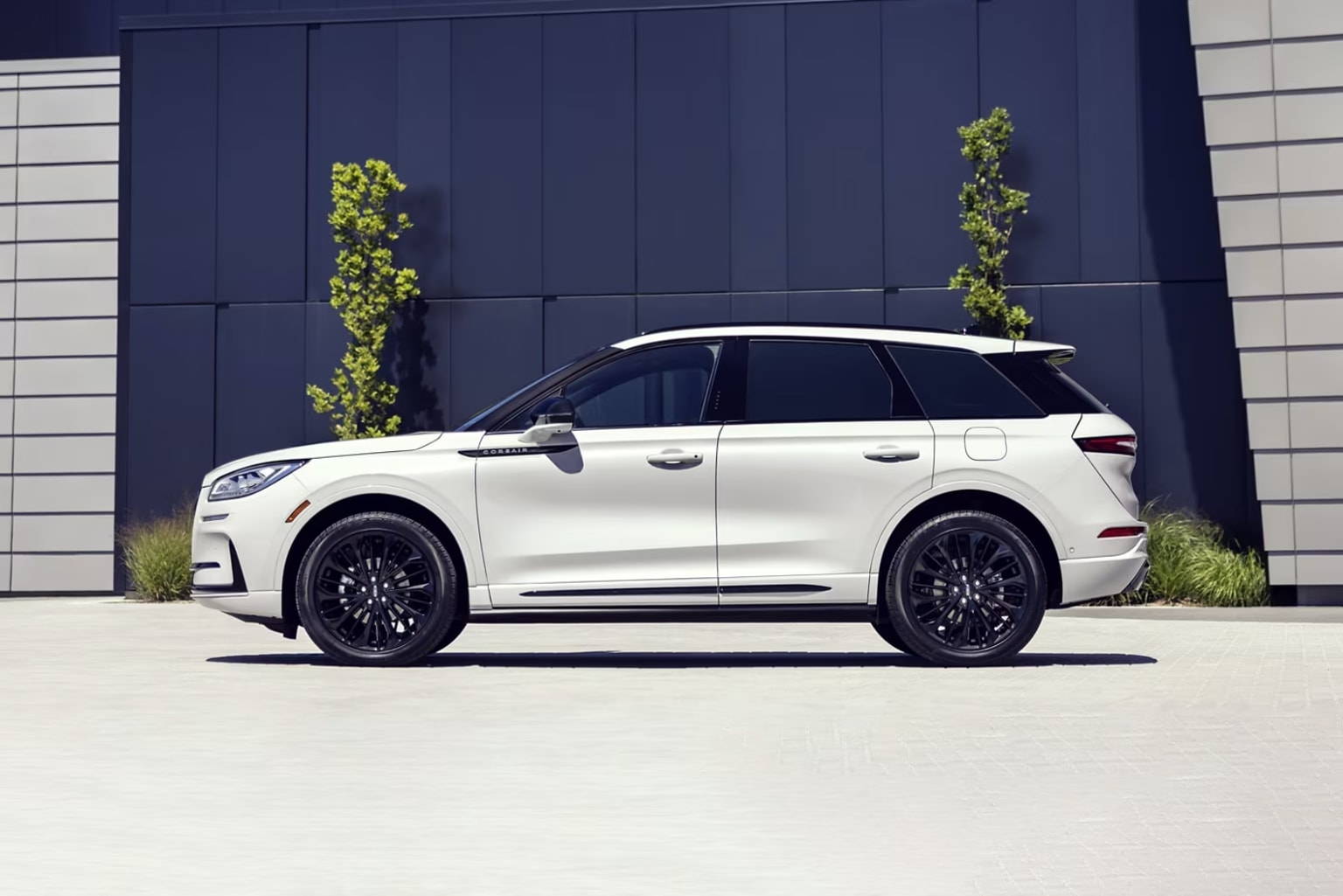 2026 Lincoln Corsair trim level photo of side view of the white luxury suv by a modern office building