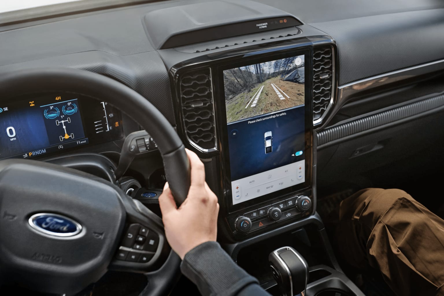 Interior of a vehicle with a large display screen showing a road view.