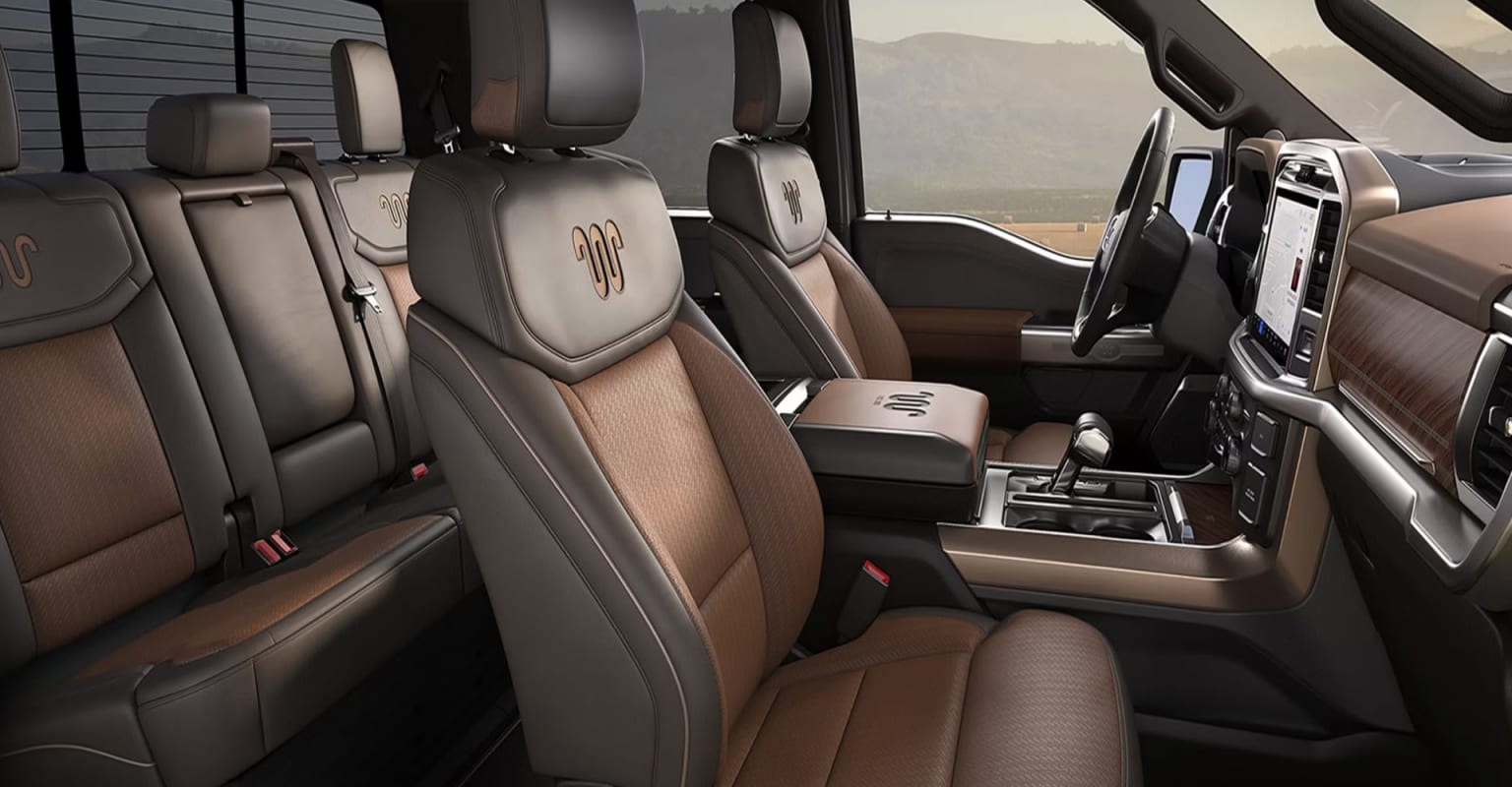 The image shows the interior of a vehicle with rows of comfortable-looking seats and various controls and features visible throughout the cabin.