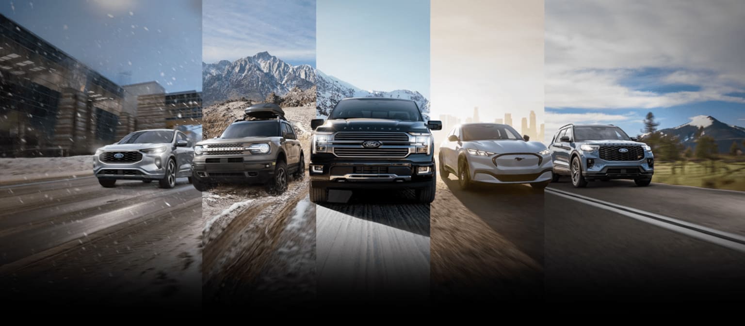 Off-road vehicles driving through snowy mountain terrain with tall peaks in the background.