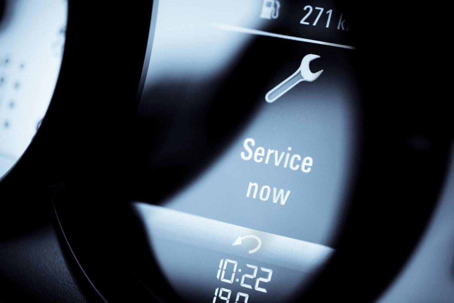Close-up view of a digital display panel showing the text "Service now" along with a wrench icon and the time "10:22".