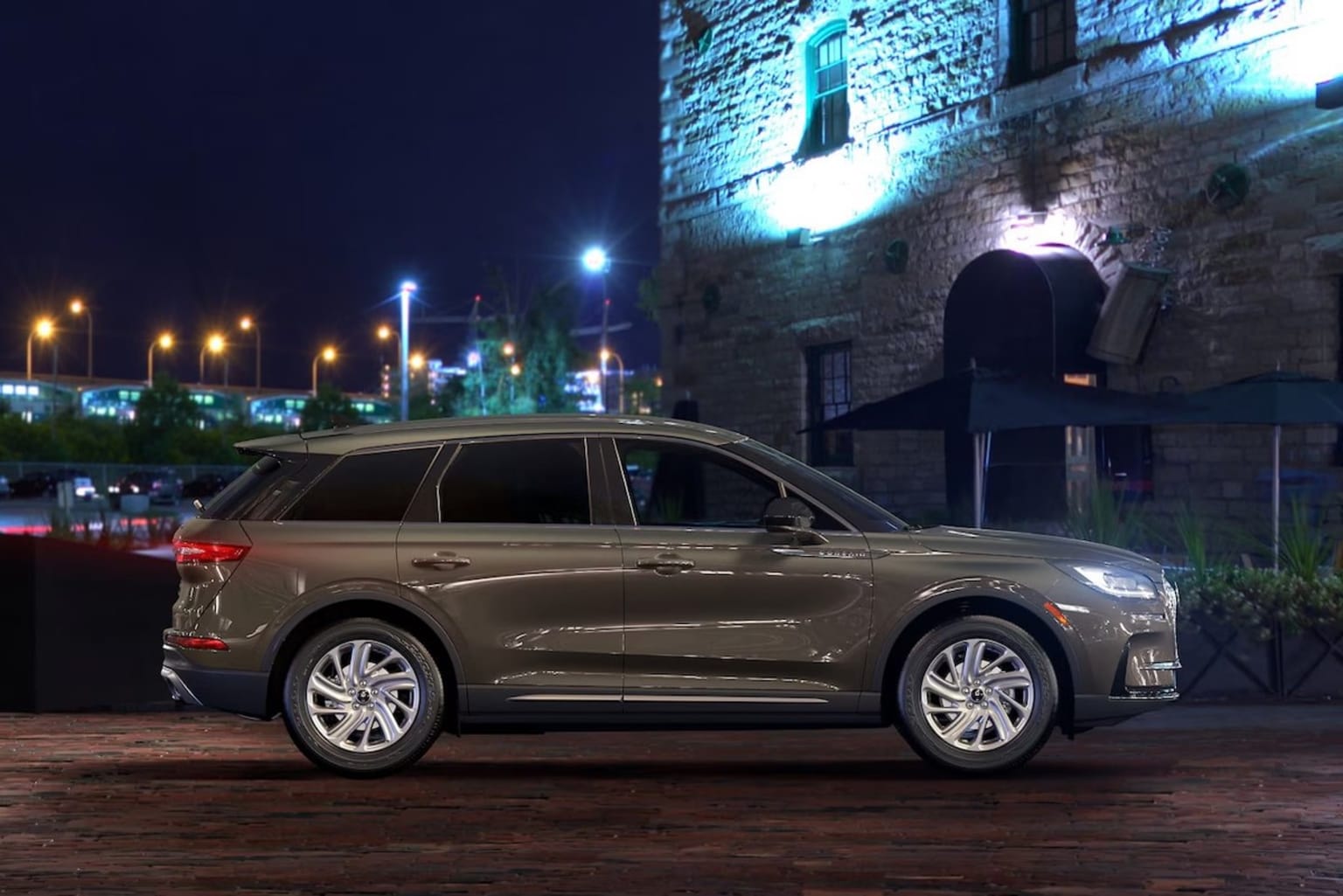 2025 Lincoln Corsair parked outside a brick building illuminated in the dark night