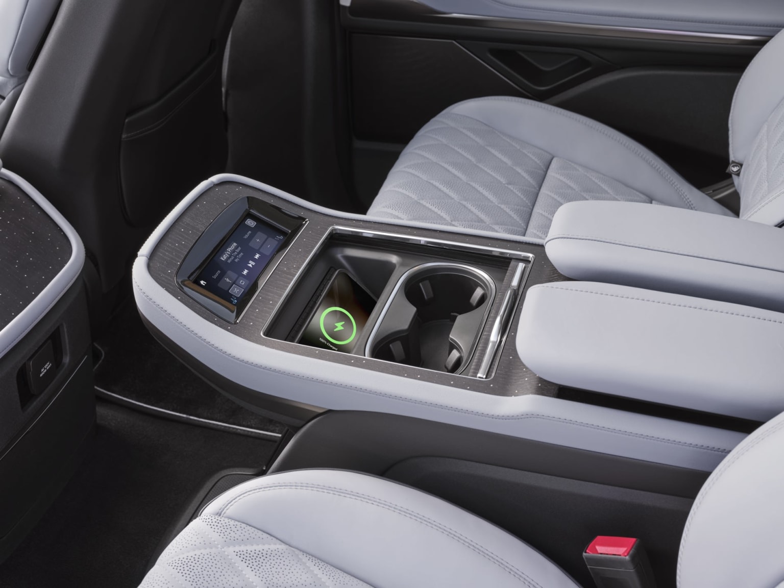 Interior of a vehicle with center console controls and display screen.