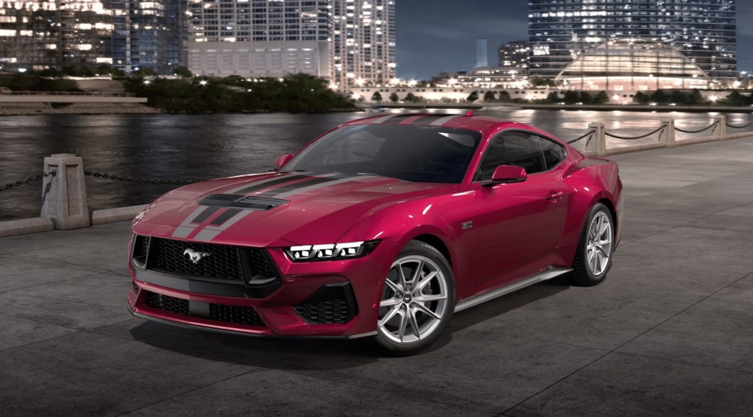 A sleek, vibrant red sports car parked on a waterfront promenade with a backdrop of towering skyscrapers and a nighttime cityscape.