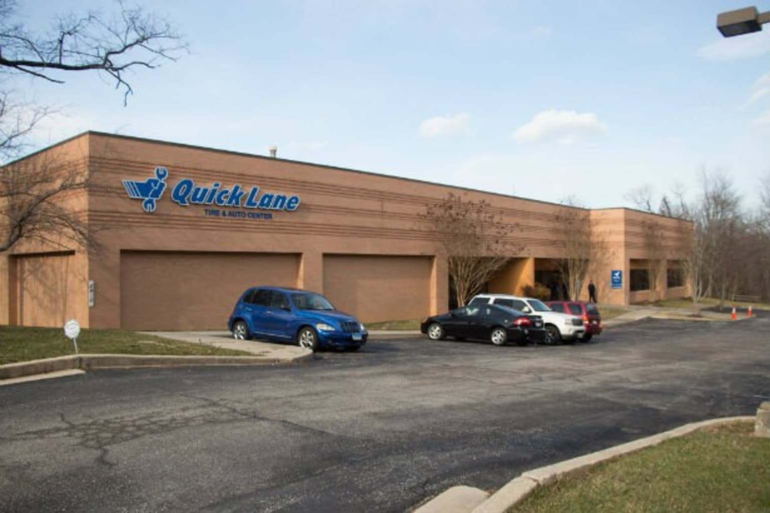 two cars parked in front of a building with a sign on the side of the building that says quicklane