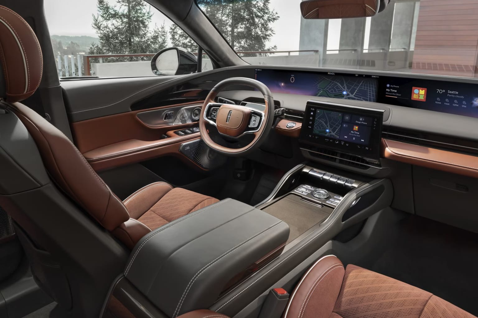 Interior of a modern luxury vehicle with a sleek dashboard, large touchscreen display, leather-upholstered seats, and a panoramic view through the windshield.