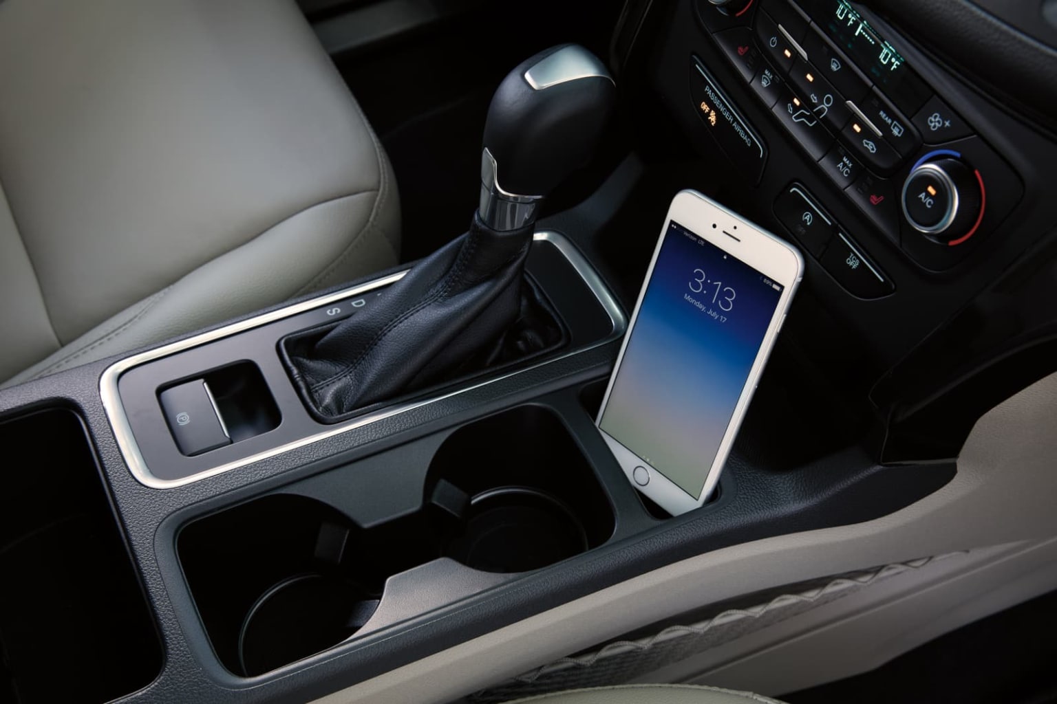 a cell phone in the center of a car with an air vent in the center of the car and a cell phone holder in the center of the car