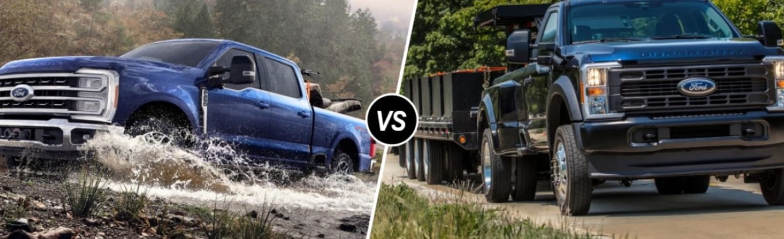 A blue truck drives through water in the foreground with a wooded background, while a dark blue truck with a trailer is on a dirt road in the background.