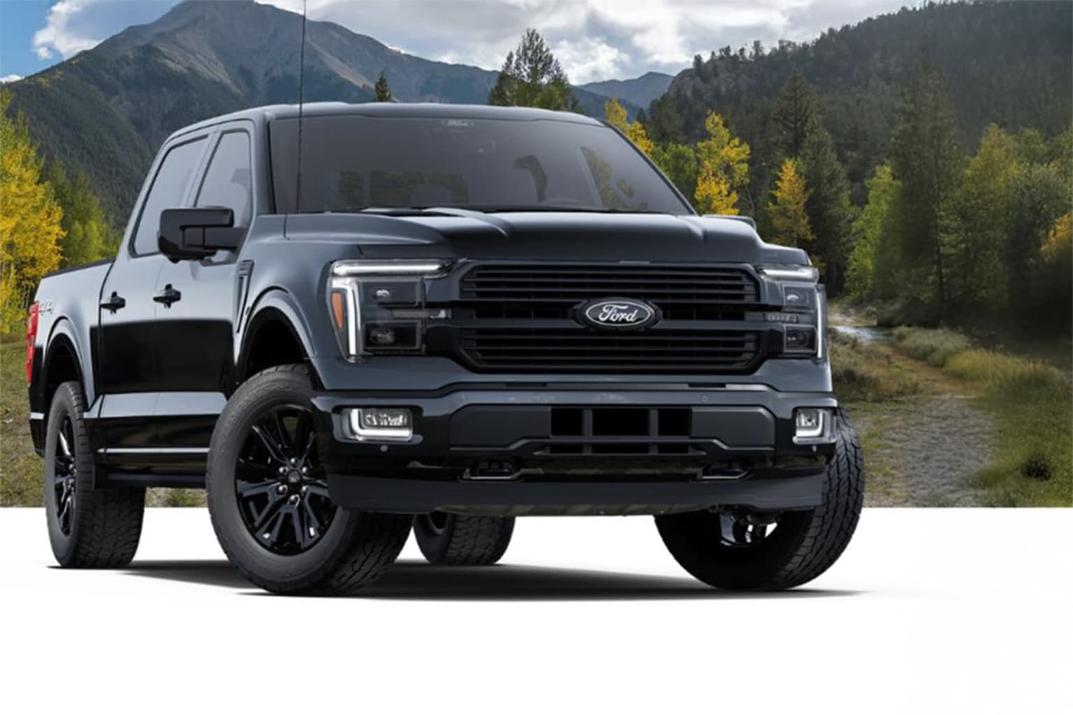 A rugged and powerful-looking pickup truck stands in the foreground, surrounded by a picturesque mountain landscape with lush forests and a winding dirt road in the background.
