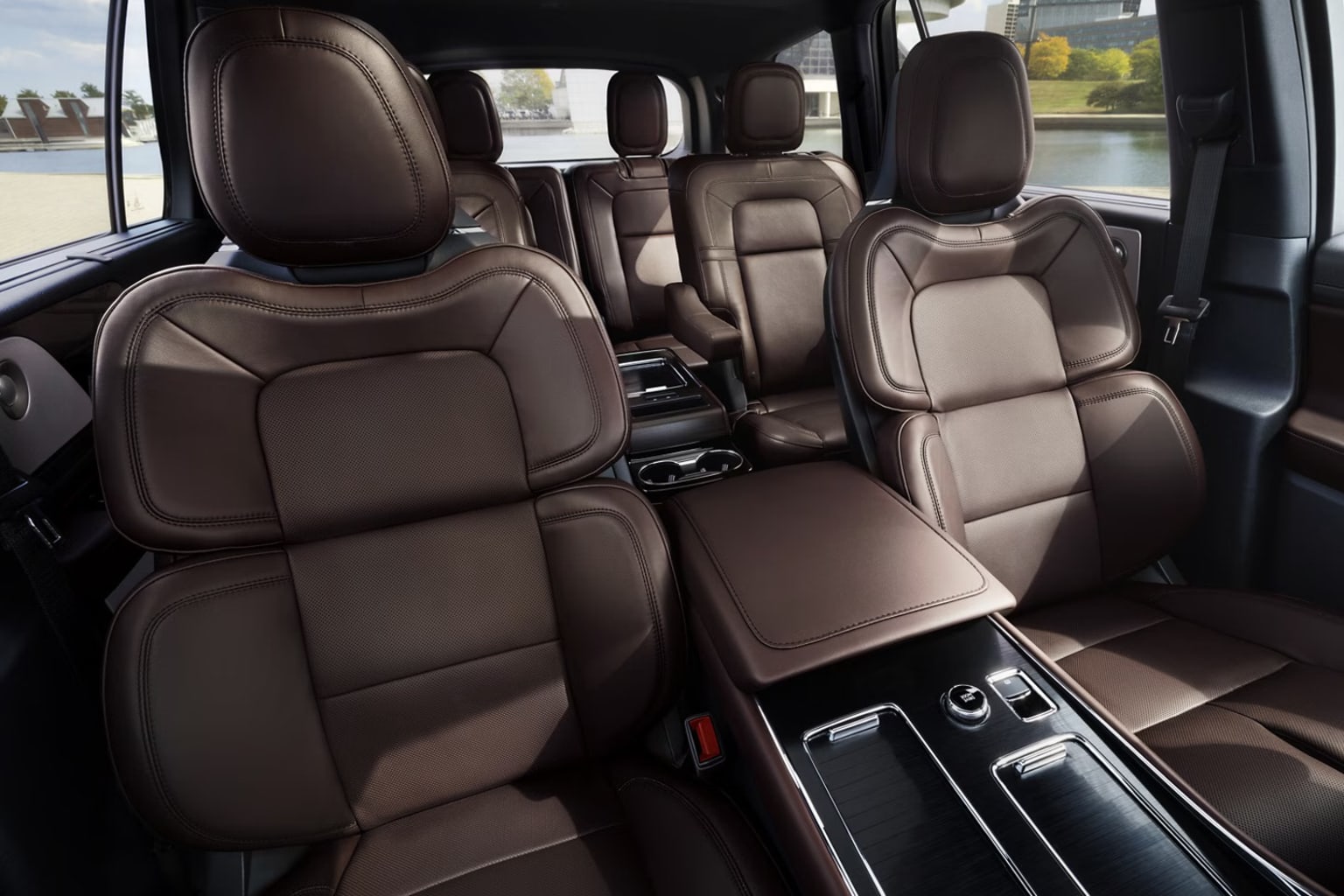 Interior of a vehicle with comfortable leather seats and a sleek, modern design. Background suggests view from inside a parking lot or garage.