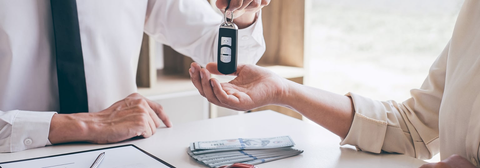 The image shows a person's hands holding a small electronic device, likely a blood glucose meter, against the backdrop of a table with stacks of cash.