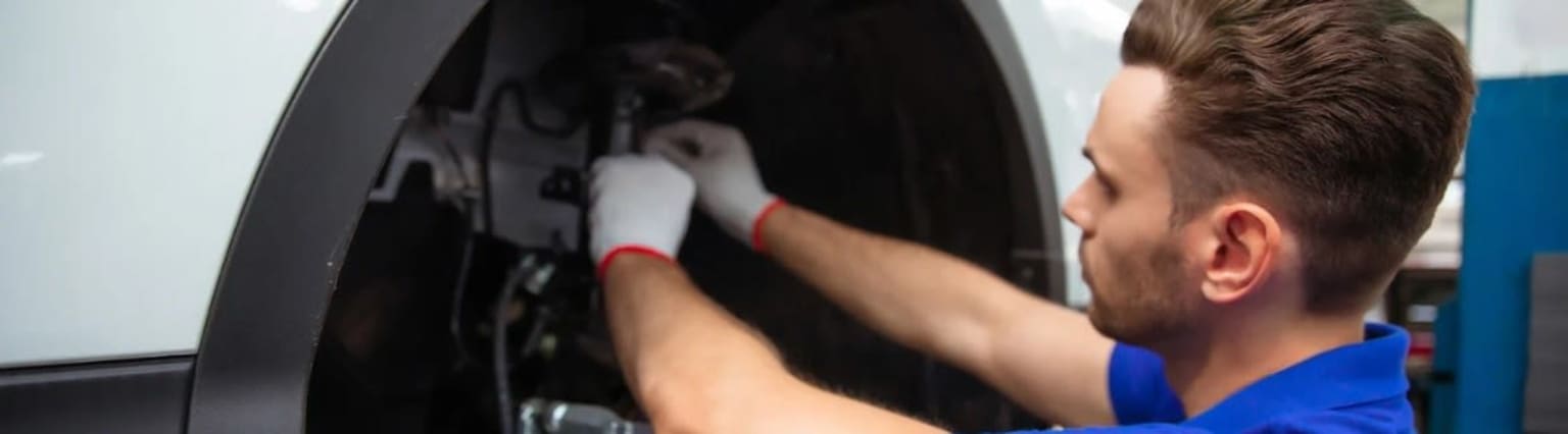 Hands reaching into a dark and shadowy area in an automotive dealership.