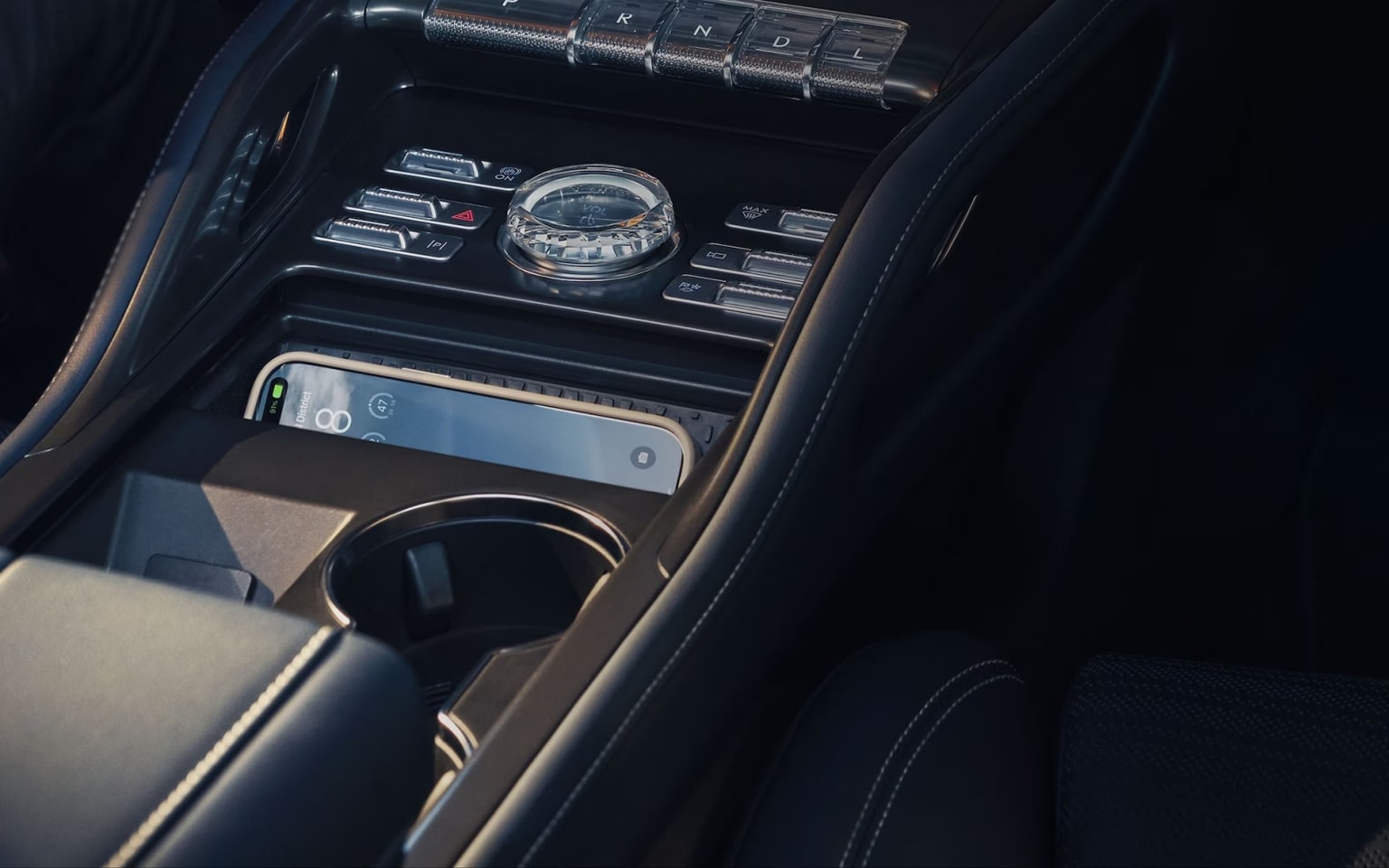 Interior of a vehicle with controls and displays, including a compass and a electronic device.