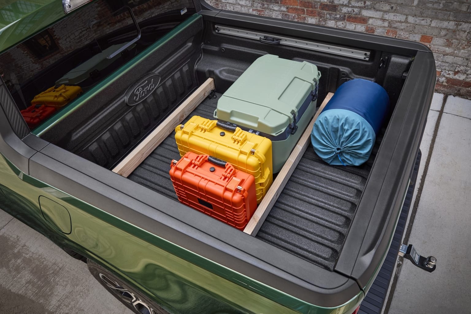 Image of open trunk filled with colorful luggage against brick wall
