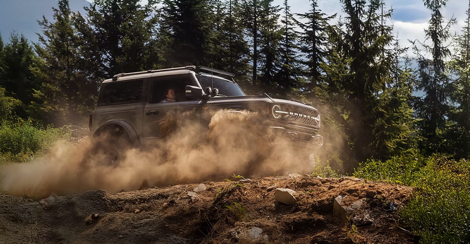 Off-road vehicle in a rocky, forested terrain.