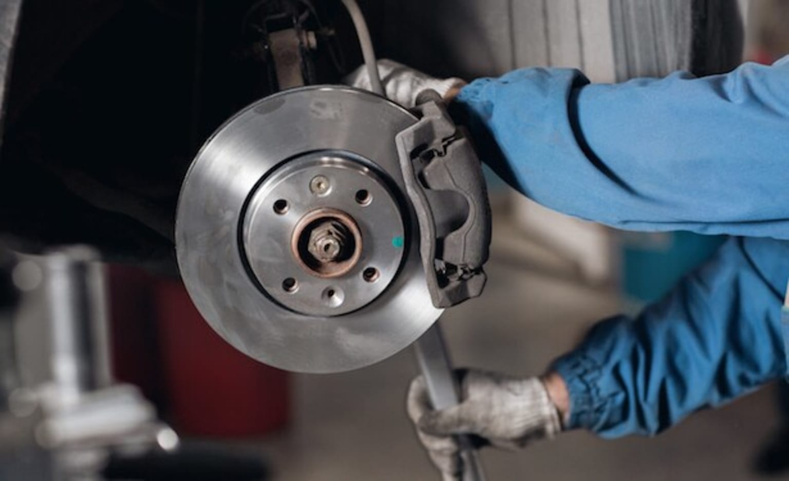 a man is working on a vehicle with a wrench and a wrench on the front of the vehicle