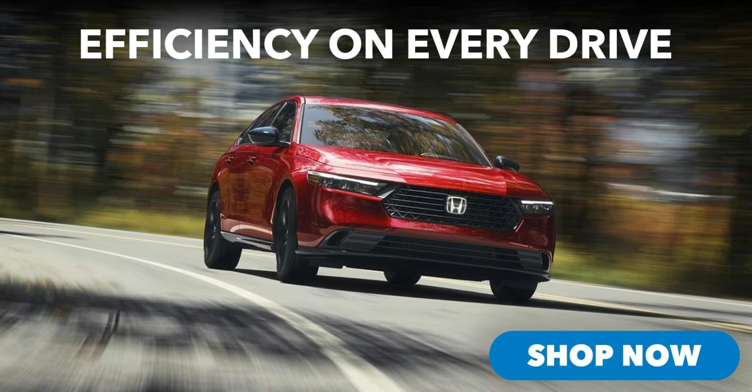 A red car driving down a road with trees in the background, with a "Shop Now" button in the foreground.
