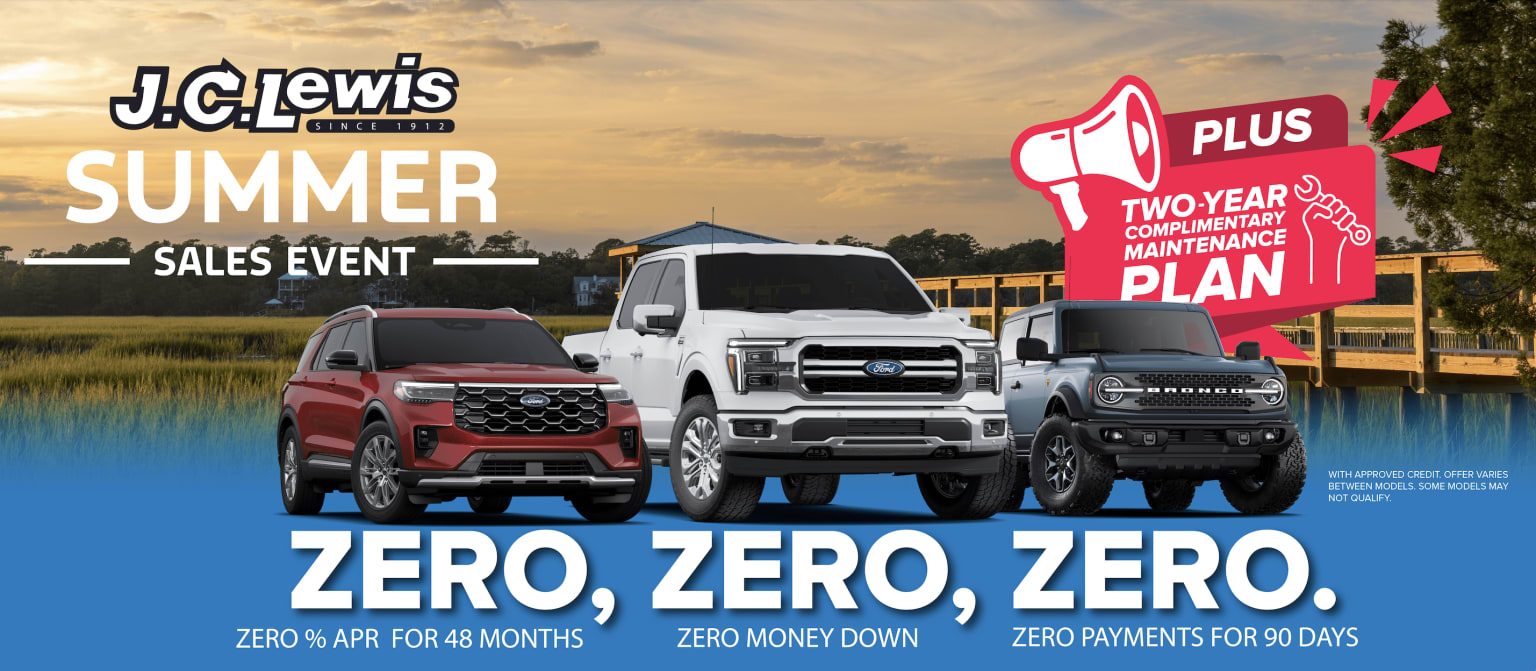 Various pickup trucks displayed at a dealership with a scenic background of a cloudy sky at sunset. Trucks featured in a promotional event with special offers.