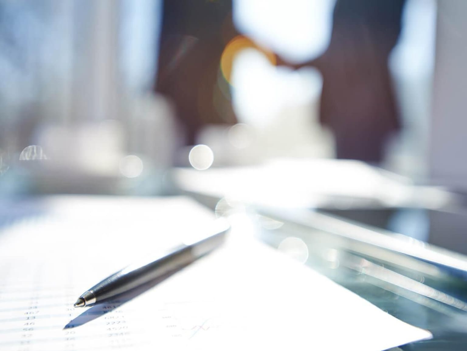 A pen on a reflective surface with blurred background.